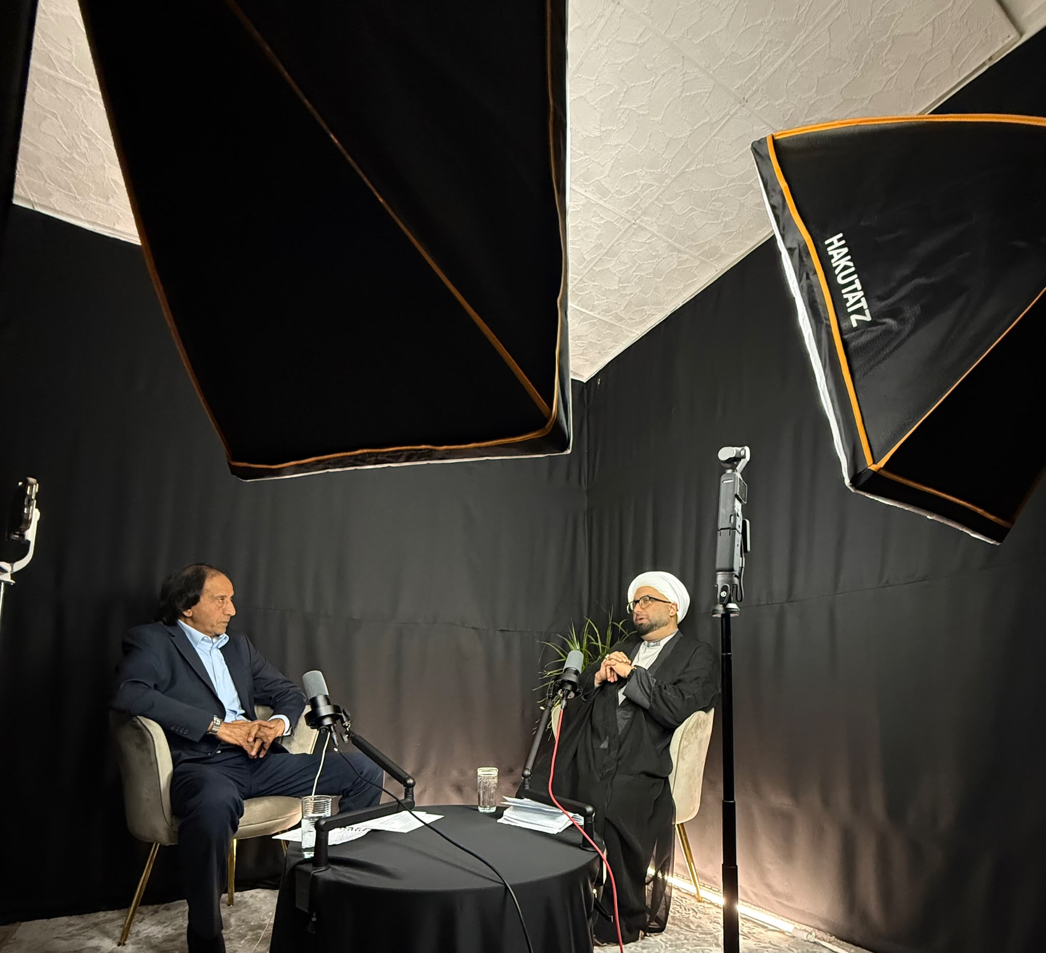 Two guests seated at microphones during a recorded studio conversation